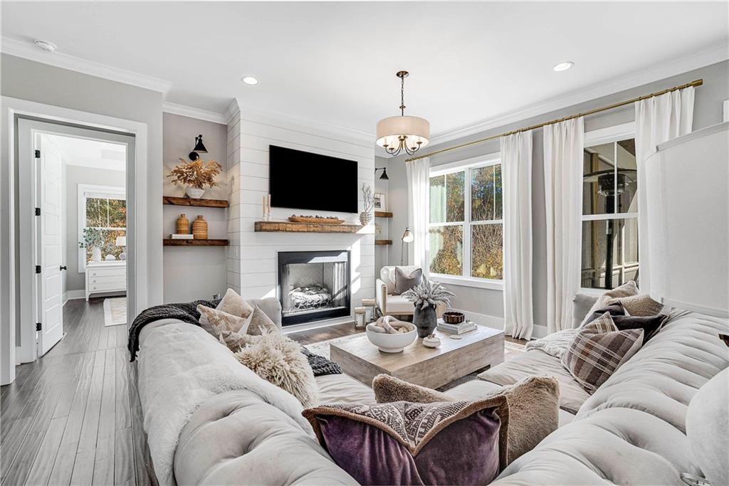 9245 Brumbelow Road Alpharetta, GA 30022 - Photo 8 of 50 a living room with furniture a flat screen tv and a fireplace