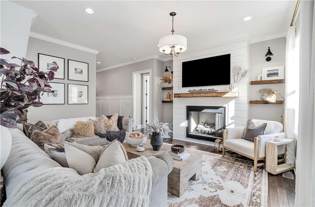9245 Brumbelow Road Alpharetta, GA 30022 - Photo 9 of 50 a living room with furniture a flat screen tv and a fireplace