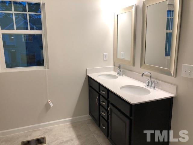6033 Beale Loop Raleigh, NC 27616 - Photo 11 of 16 a bathroom with a sink and a mirror