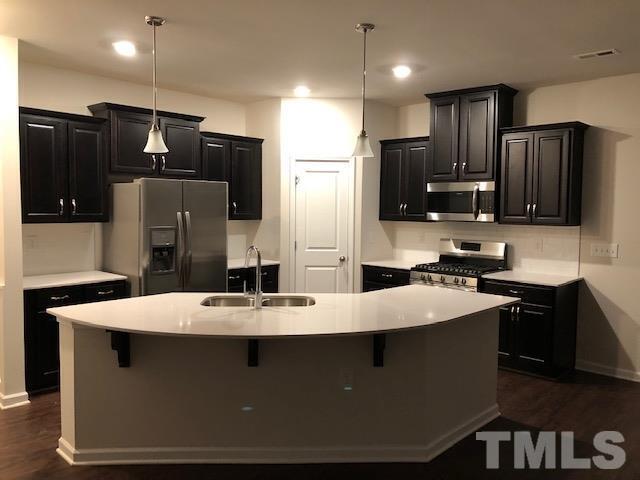 6033 Beale Loop Raleigh, NC 27616 - Photo 2 of 16 a large kitchen with stainless steel appliances wooden cabinets a refrigerator and a stove