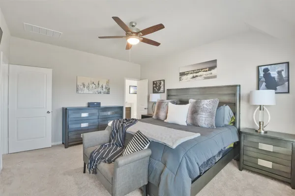 a bedroom with a large bed and a chandelier