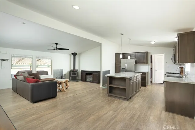 a living room with furniture flat screen tv and kitchen view