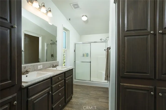 a bathroom with a double vanity sink mirror and shower