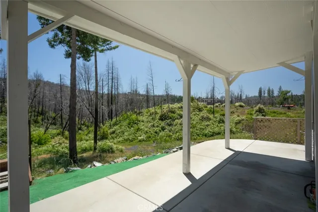 a view of a patio with table and chairs with wooden floor and fence