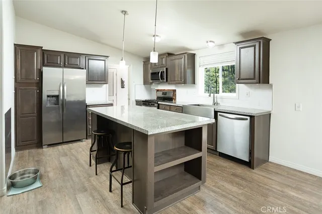 a kitchen with kitchen island a counter top space appliances and cabinets