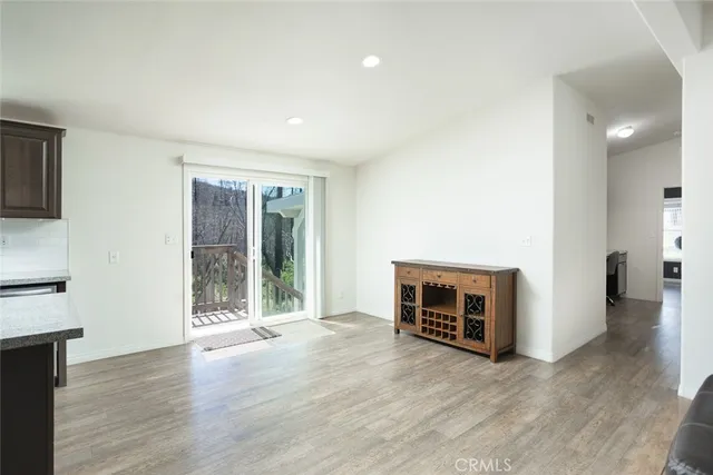 an empty room with wooden floor fireplace and windows
