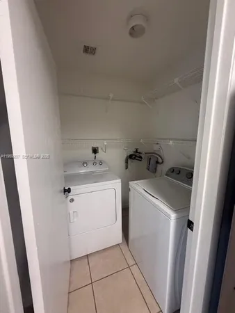 a utility room with cabinets washer and dryer