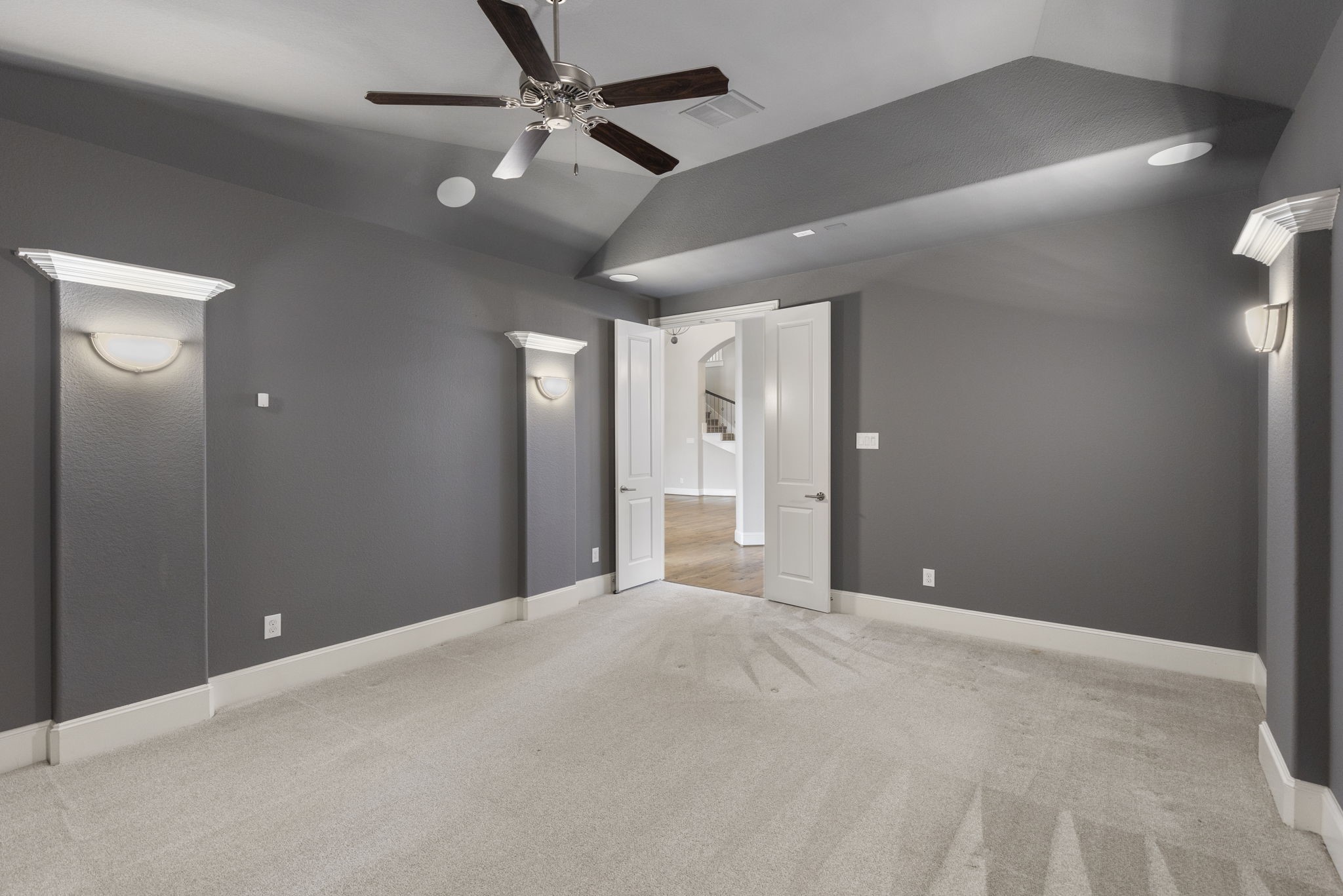 25002 Rosa Aurora Way Spring, TX 77389 - Photo 17 of 38 This media room features a modern design with gray walls, plush carpeting, and recessed lighting.