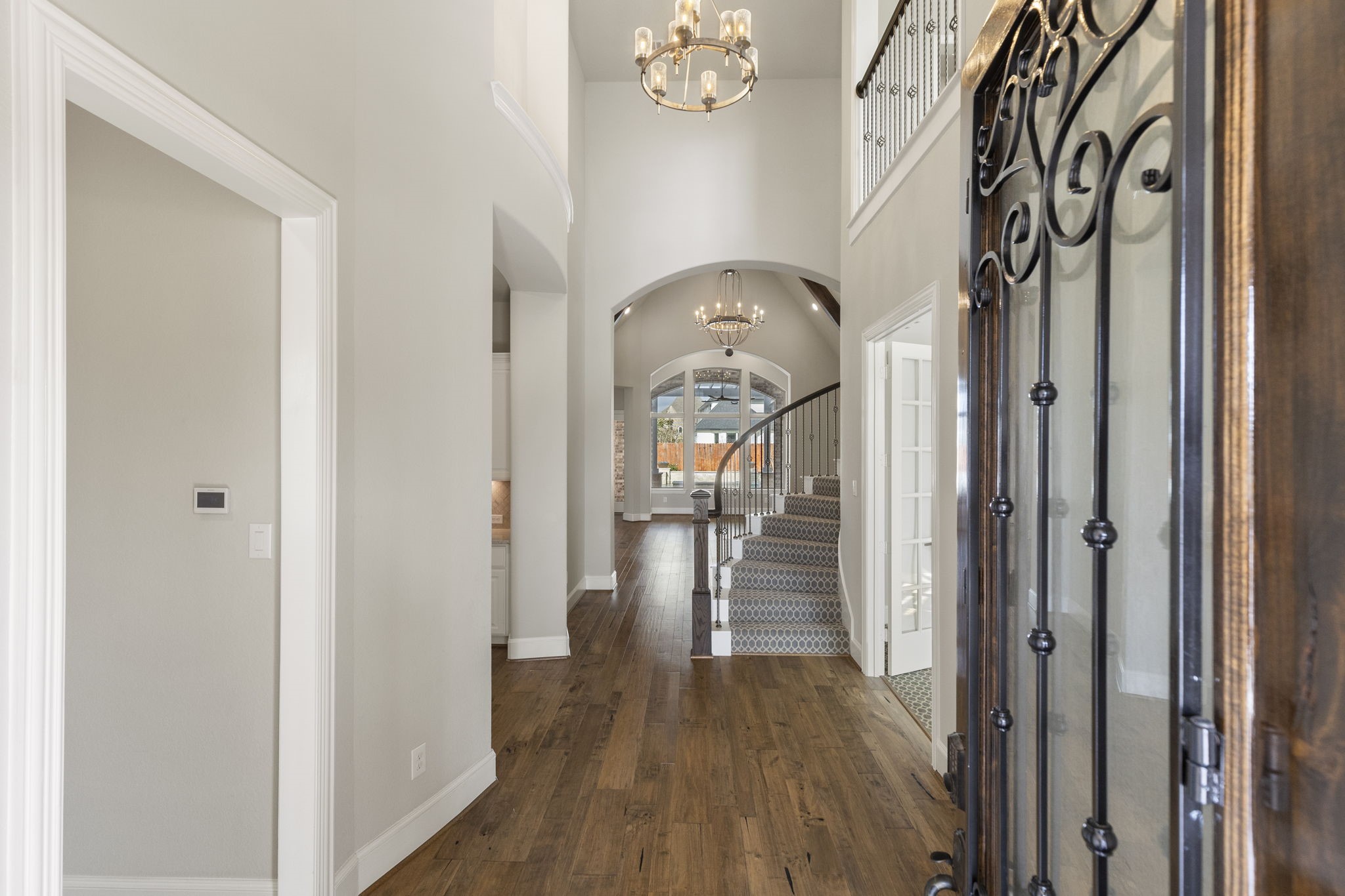 25002 Rosa Aurora Way Spring, TX 77389 - Photo 4 of 38 This inviting entryway features a grand staircase with elegant carpeting, high ceilings, and stylish chandeliers.