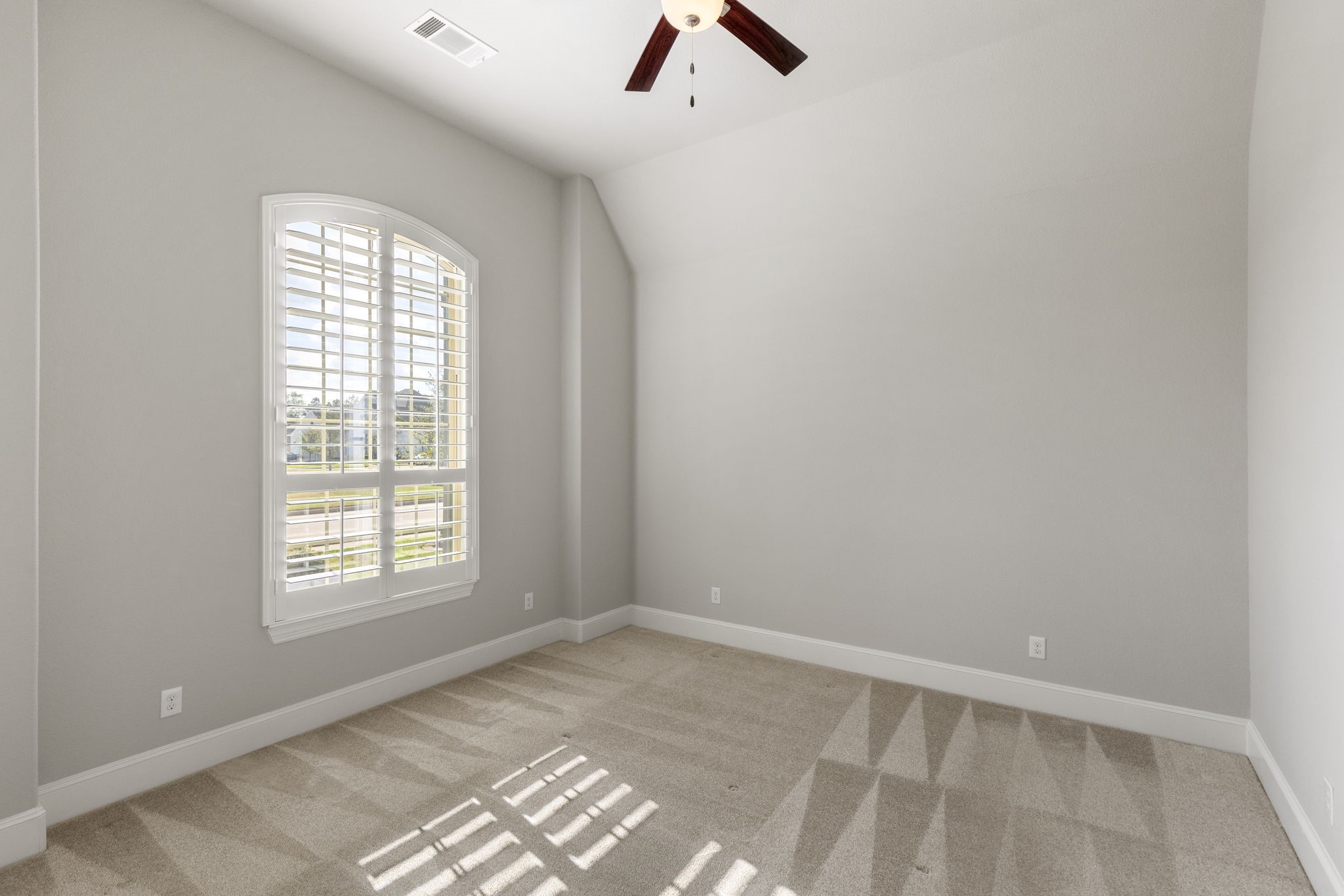 25002 Rosa Aurora Way Spring, TX 77389 - Photo 8 of 38 This secondary Jr. Suite features neutral walls, a high ceiling with a ceiling fan, and a large window with shutters that allow natural light to fill the space.