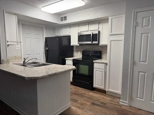 a kitchen with stainless steel appliances granite countertop a refrigerator stove and microwave