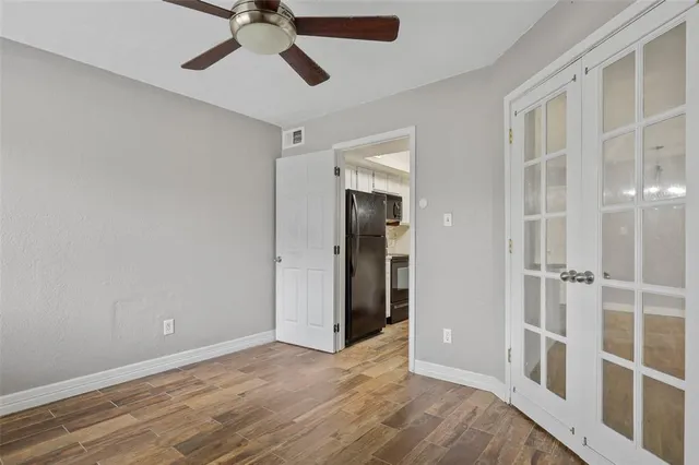 a view of a room with a ceiling fan and entryway