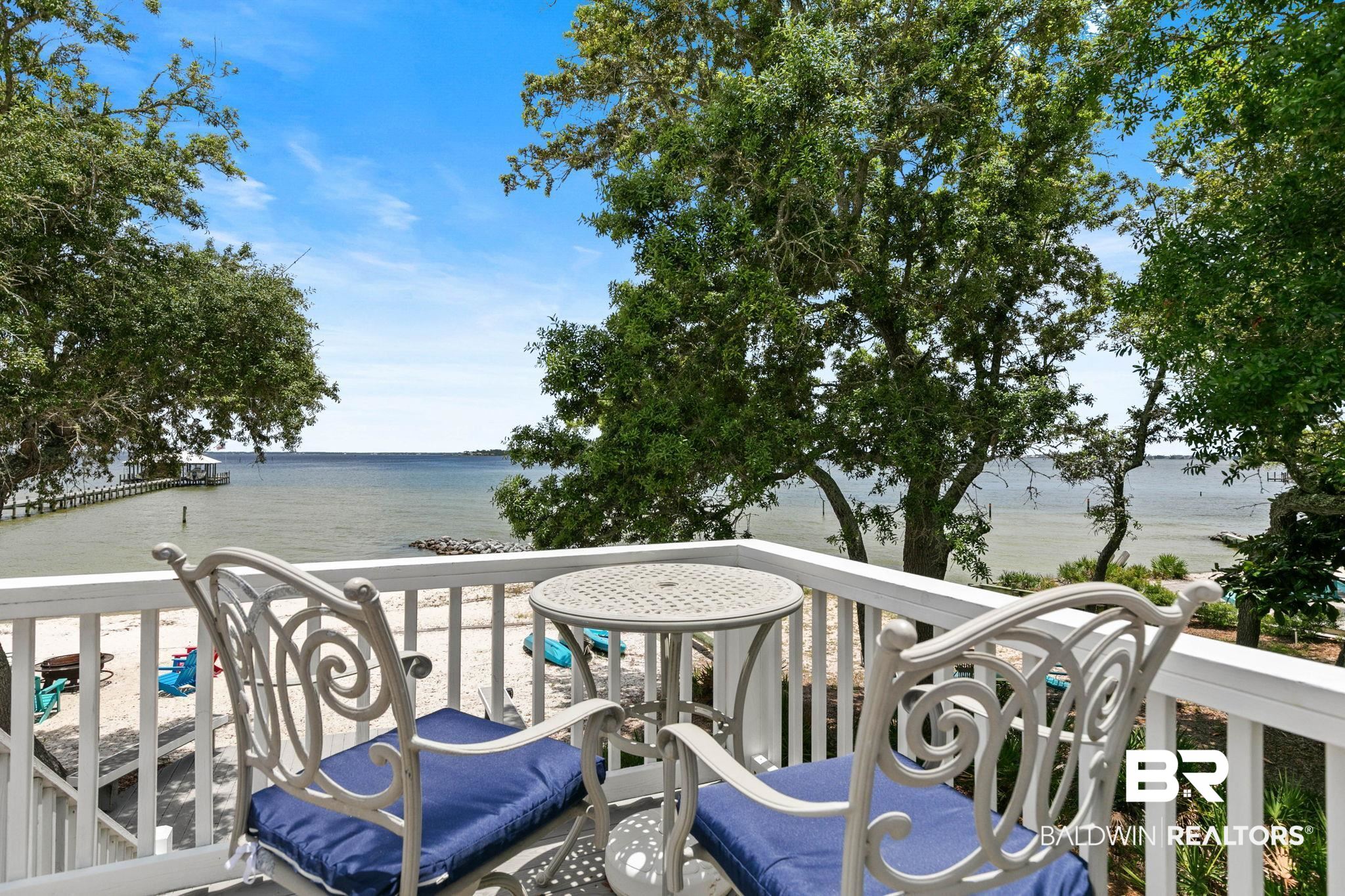 6802 Shore Drive Elberta, AL 36530 - Photo 11 of 34 Balcony with white wooden railing overlooking a sandy beach and expansive body of water