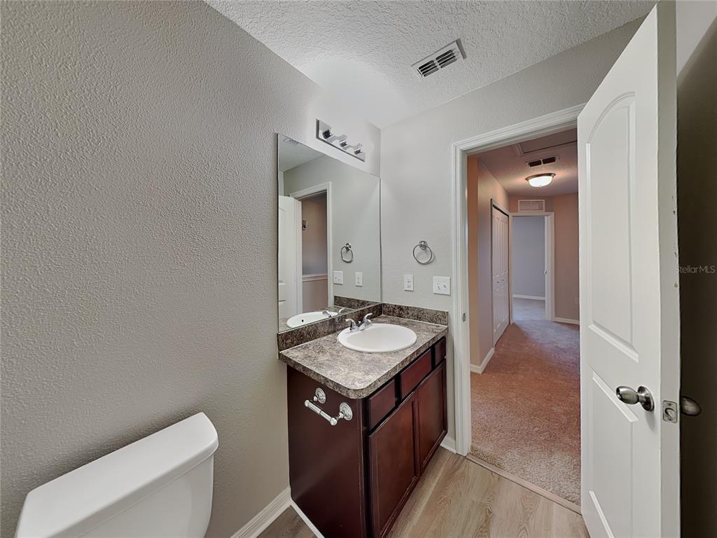 Undisclosed Address Spring Hill, FL 34609 - Photo 13 of 15 a bathroom with a granite countertop sink and a mirror with toilet