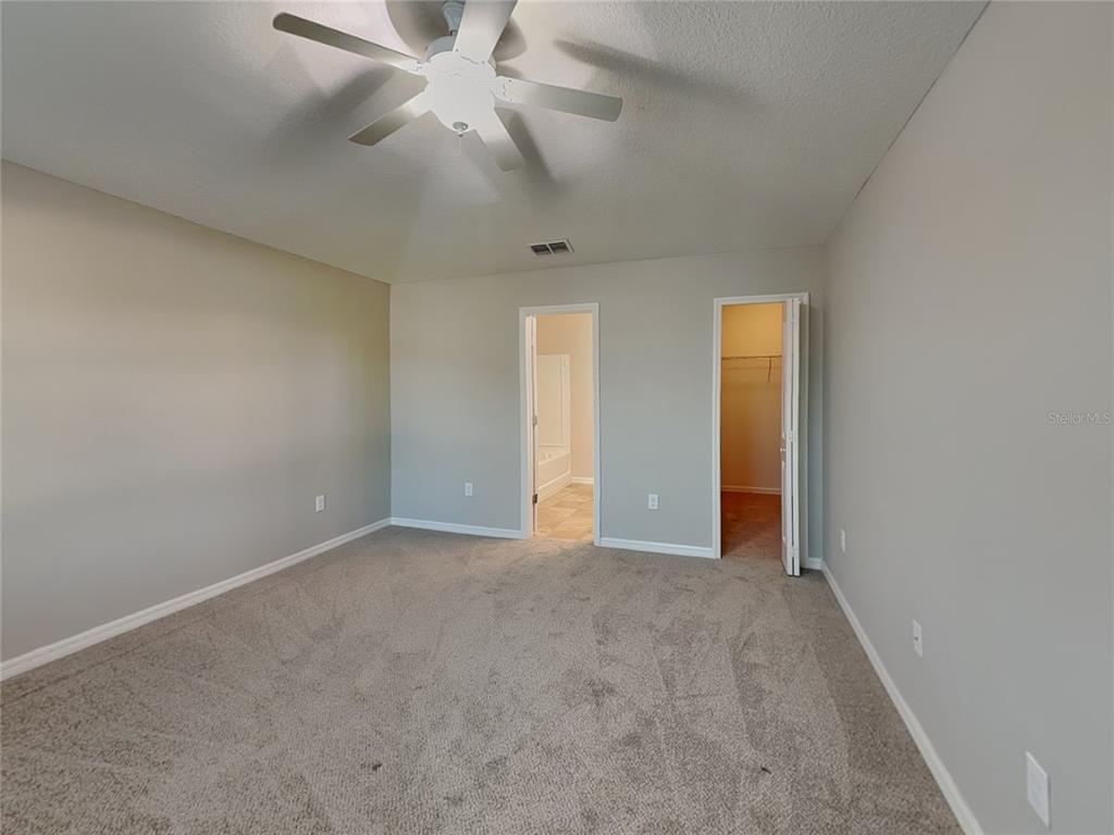 Undisclosed Address Spring Hill, FL 34609 - Photo 6 of 15 an empty room with closet and a chandelier fan