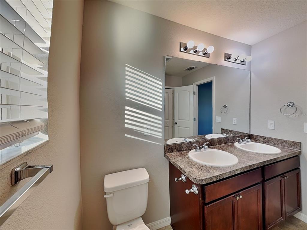 Undisclosed Address Spring Hill, FL 34609 - Photo 7 of 15 a bathroom with a granite countertop sink and a mirror