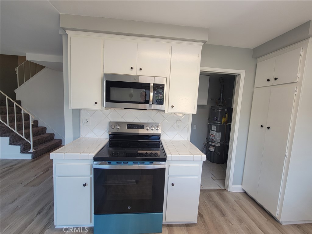 14325 Blackpool Road Westminster, CA 92683 - Photo 12 of 28 a kitchen with cabinets stainless steel appliances and wooden floor