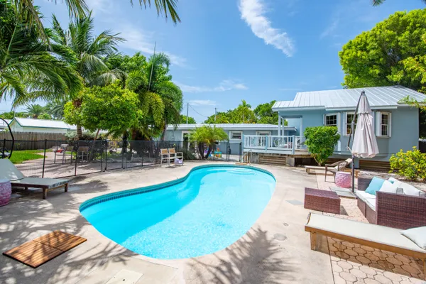 a view of a swimming pool with couches chairs and potted plants