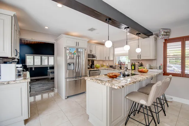 a kitchen with stainless steel appliances kitchen island granite countertop a sink and cabinets