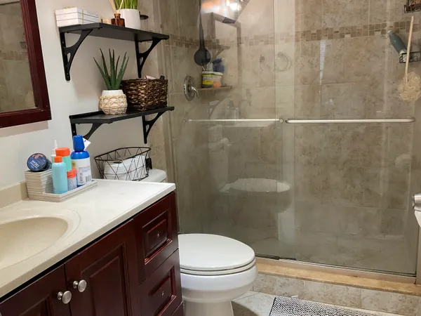 a bathroom with a sink a toilet and shower