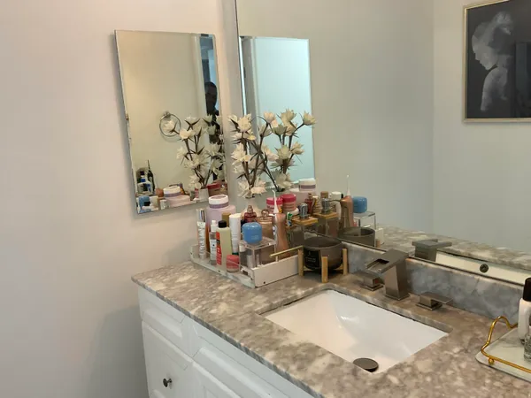 a bathroom with a granite countertop sink and a mirror