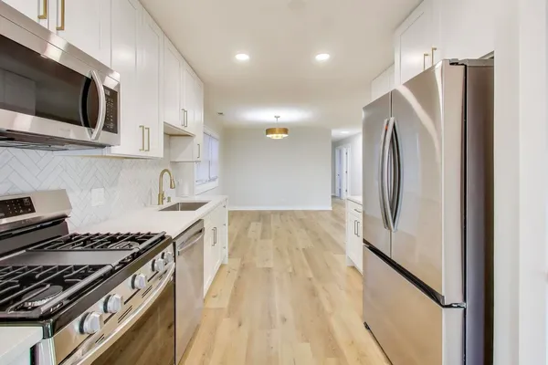 a kitchen with stainless steel appliances granite countertop a stove and a refrigerator
