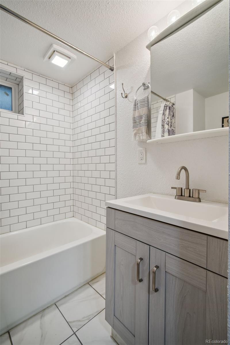 60 Perry Street Denver, CO 80219 - Photo 31 of 43 a bathroom with a bathtub shower sink vanity and mirror