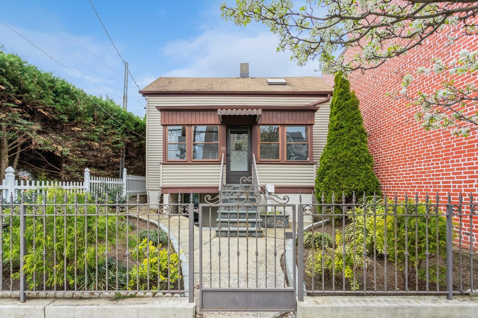 Bungalow-style home featuring entry steps, a fenced front yard, and a gate