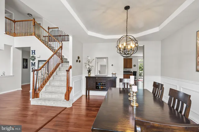 a view of a dining room and livingroom with furniture wooden floor a chandelier