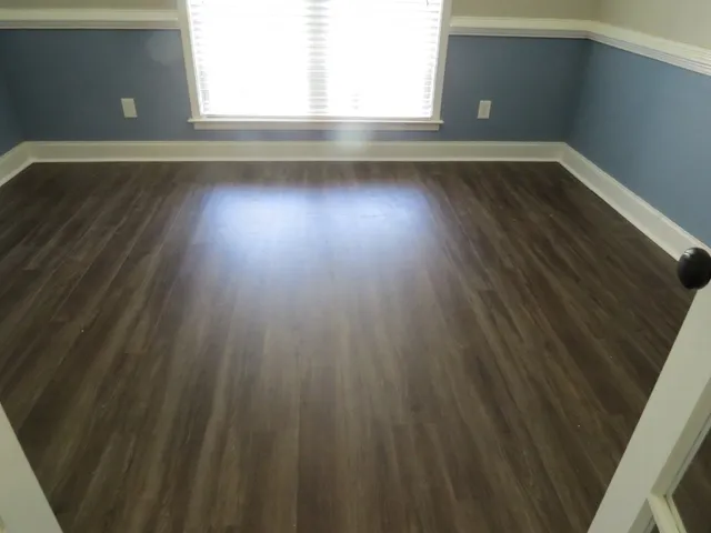 a view of a room with wooden floor and a window