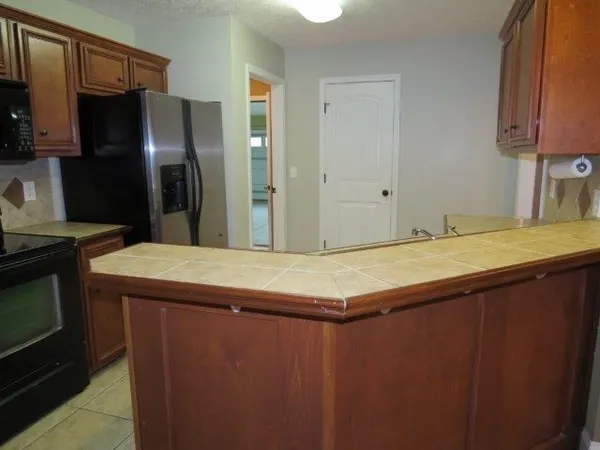 a kitchen with kitchen island a counter top space cabinets and stainless steel appliances