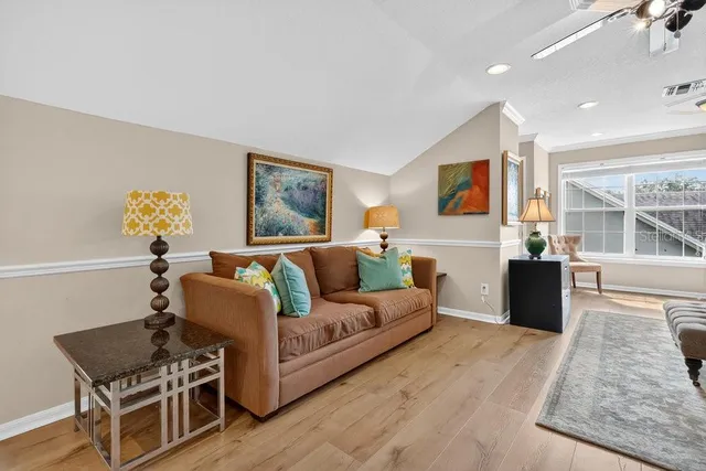 a bedroom with a bed and dresser with wooden floor
