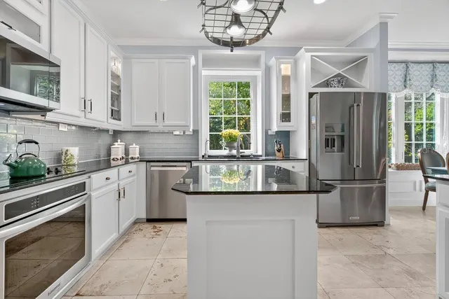 a kitchen with stainless steel appliances granite countertop a stove and cabinets