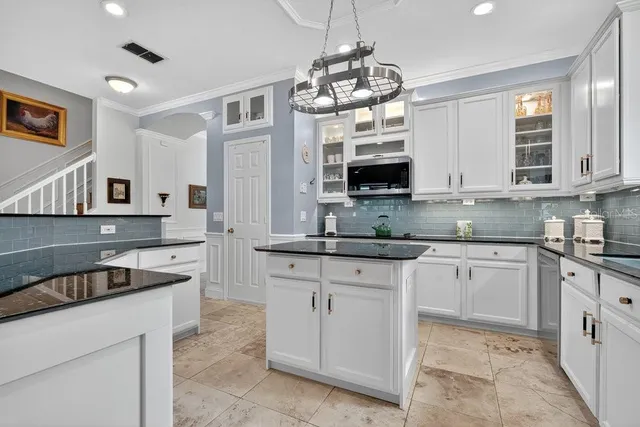 a kitchen with stainless steel appliances kitchen island granite countertop a table and chairs in it