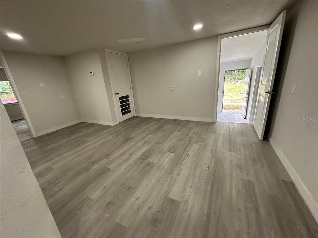 17405 Northeast 38th Lane Road Silver Springs, FL 34488 - Photo 11 of 25 an empty room with wooden floor and windows