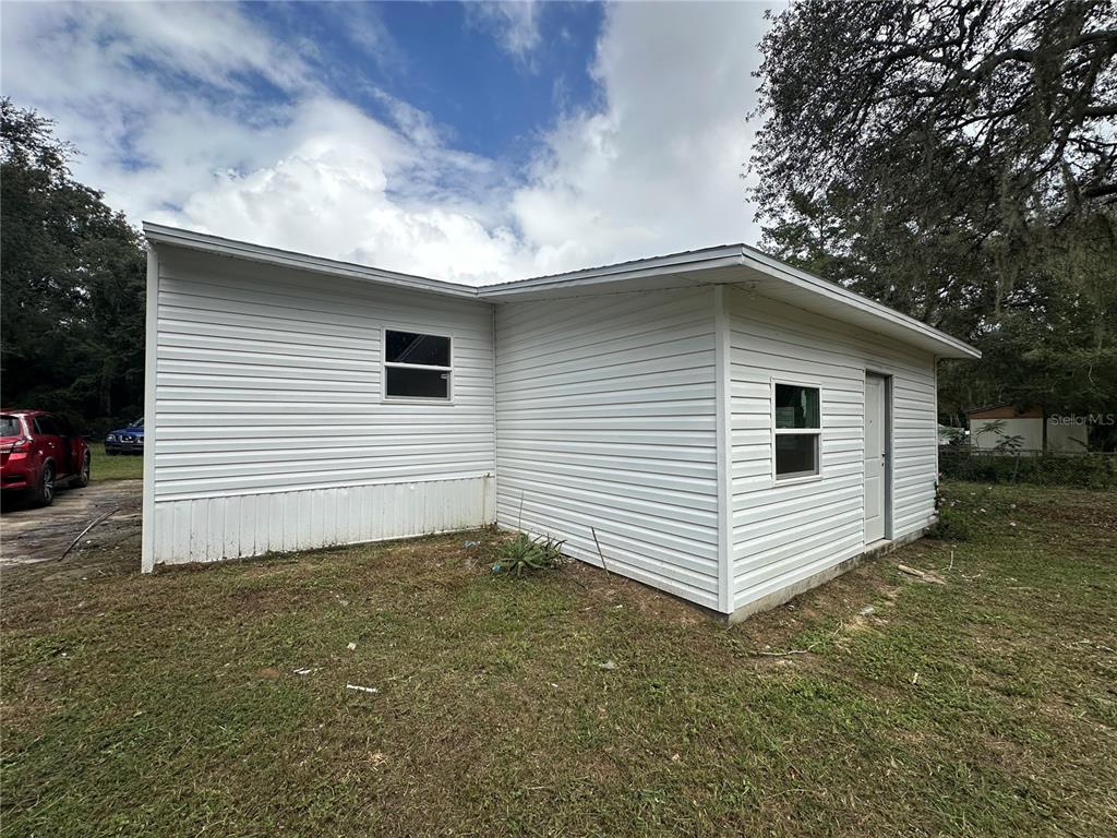 17405 Northeast 38th Lane Road Silver Springs, FL 34488 - Photo 4 of 25 a view of a white house with a yard