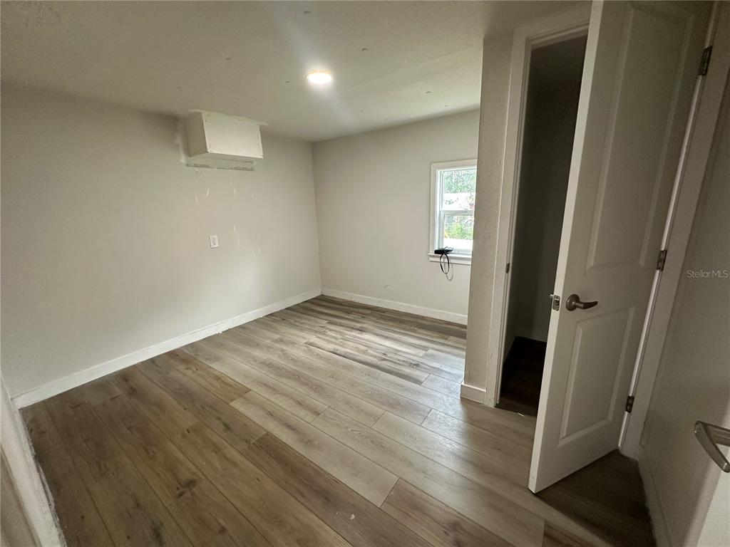 17405 Northeast 38th Lane Road Silver Springs, FL 34488 - Photo 8 of 25 an empty room with wooden floor and entrance