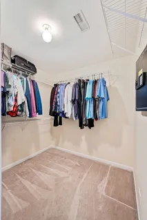 a view of walk in closet with clothes and shoes