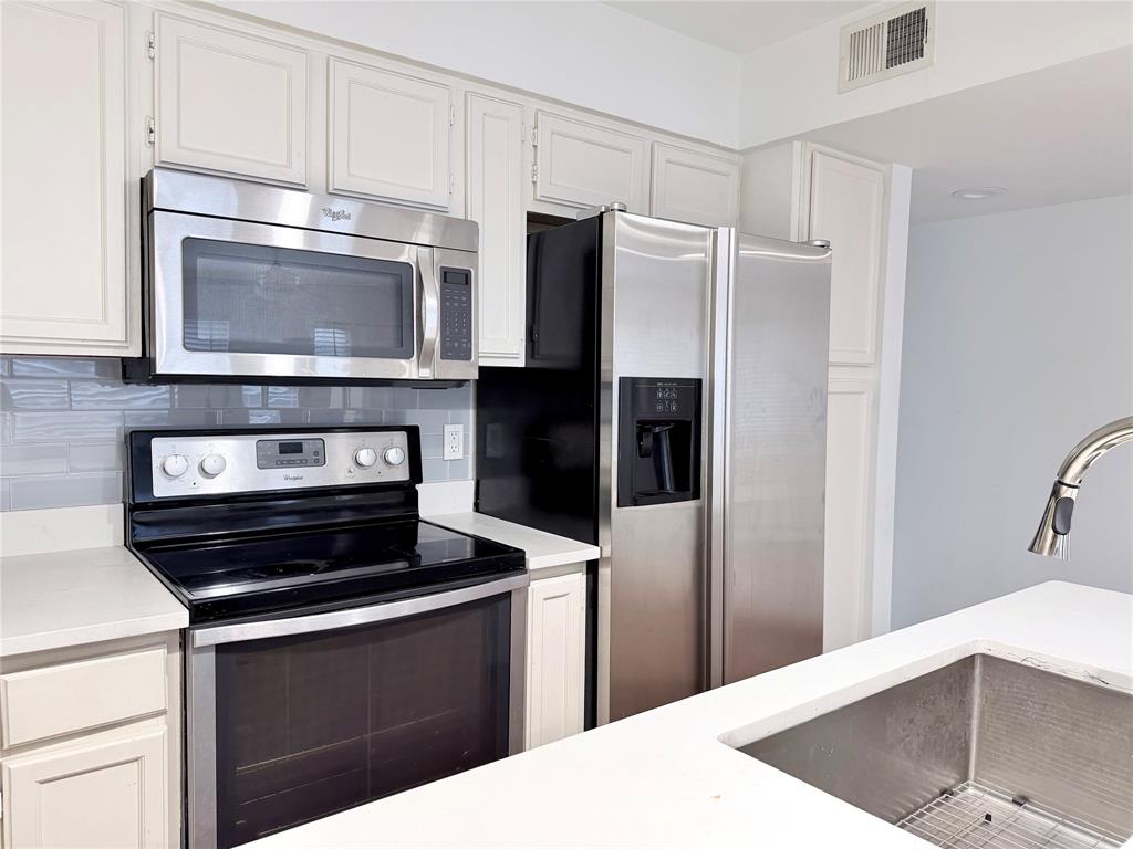 4411 Gilbert Avenue, Unit 10 Dallas, TX 75219 - Photo 5 of 11 a kitchen with cabinets and stainless steel appliances