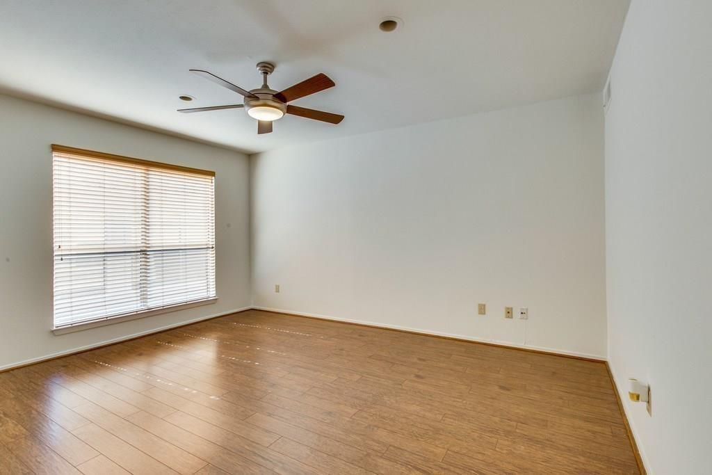 4411 Gilbert Avenue, Unit 10 Dallas, TX 75219 - Photo 8 of 11 an empty room with wooden floor fan and windows