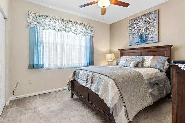 a bed sitting in a bedroom next to a window and a chandelier