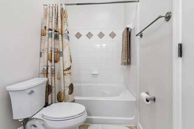 a white toilet sitting next to a bath tub and shower