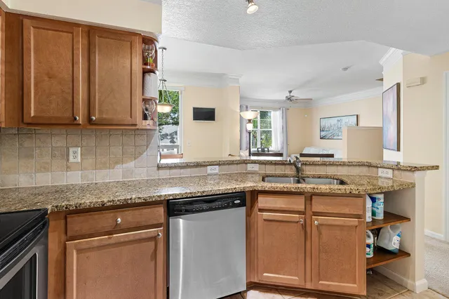 a kitchen with granite countertop cabinets sink and white appliances