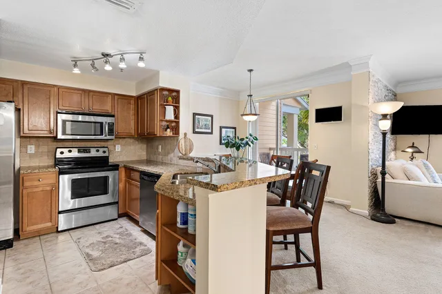 a kitchen that has a table chairs and stainless steel appliances