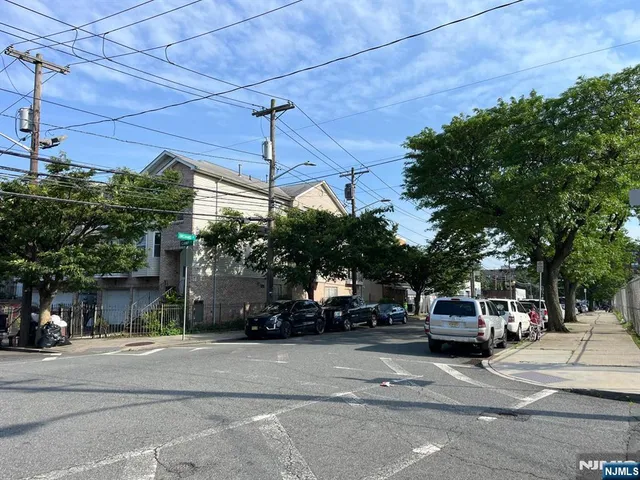a view of a city street with parked cars
