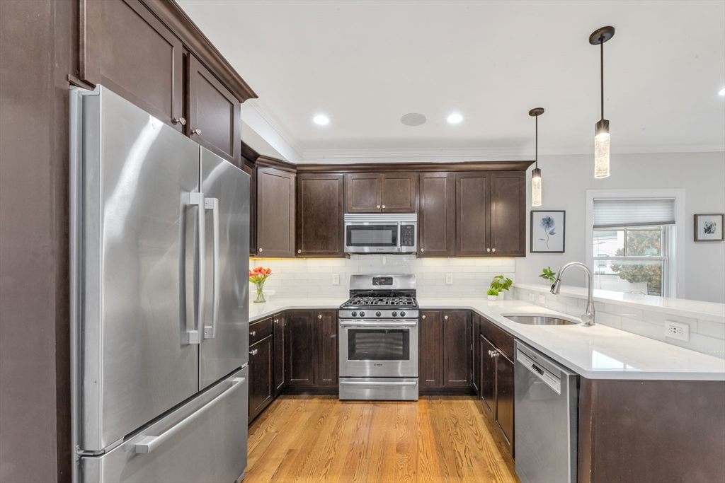 18 Robert Street, Unit 4 Boston, MA 02131 - Photo 2 of 25 a kitchen with kitchen island a counter top space stainless steel appliances and cabinets