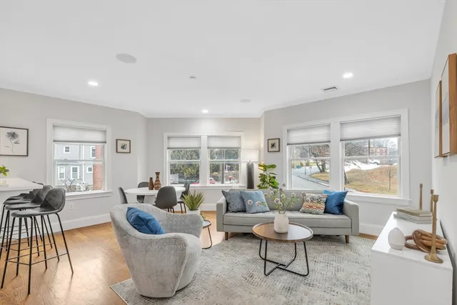 a living room with furniture and floor to ceiling windows