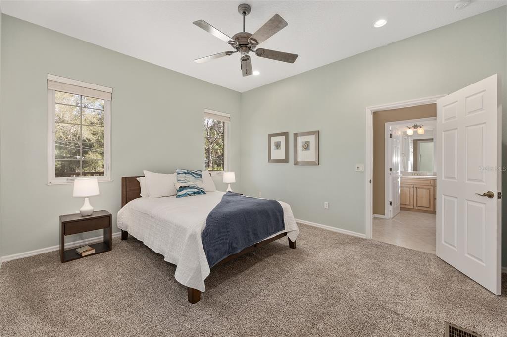 11944 West Creekside Lane Homosassa, FL 34448 - Photo 34 of 90 a spacious bedroom with a bed and a chandelier