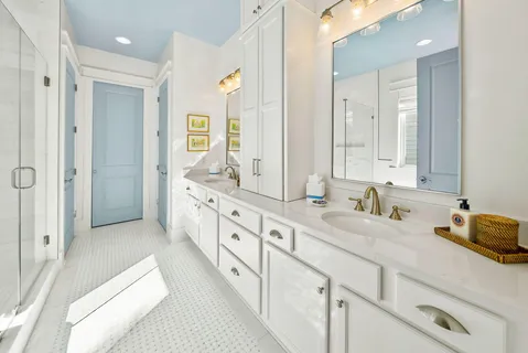 a spacious en suite bathroom with double sink and a mirror