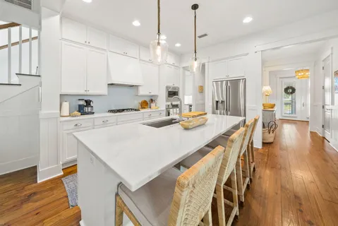 a kitchen with a sink a center island stainless steel appliances and cabinets